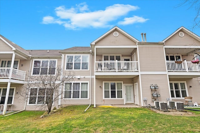 back of property with a lawn and central AC unit