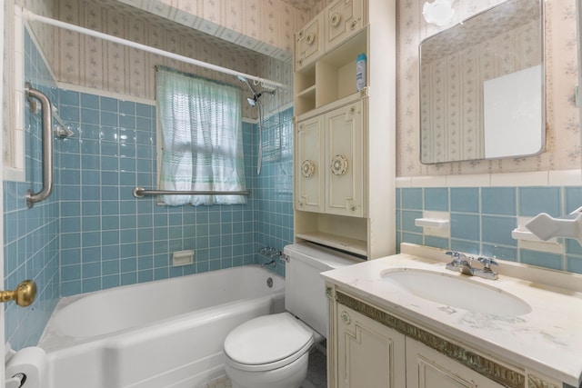 full bathroom with vanity, toilet, tile walls, and tiled shower / bath