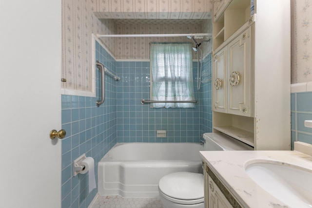 full bathroom with tile patterned flooring, toilet, vanity, tile walls, and tiled shower / bath