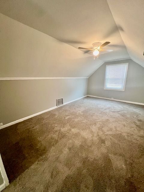 additional living space featuring carpet, ceiling fan, and vaulted ceiling