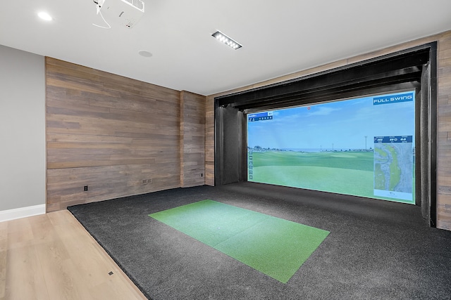 rec room featuring golf simulator and wooden walls