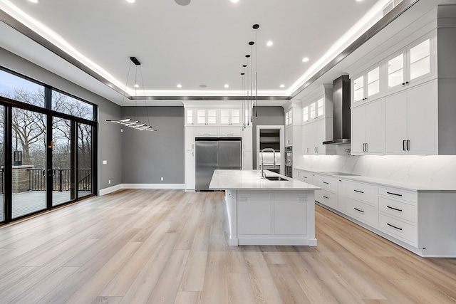 kitchen with pendant lighting, white cabinets, a center island with sink, sink, and appliances with stainless steel finishes