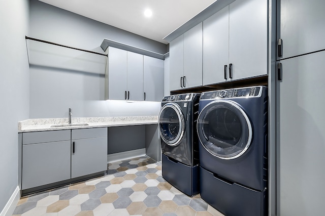 laundry area with separate washer and dryer, sink, and cabinets