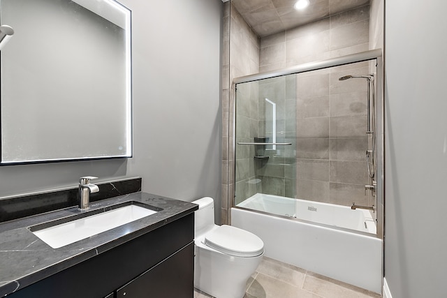 full bathroom featuring tile patterned floors, toilet, vanity, and combined bath / shower with glass door