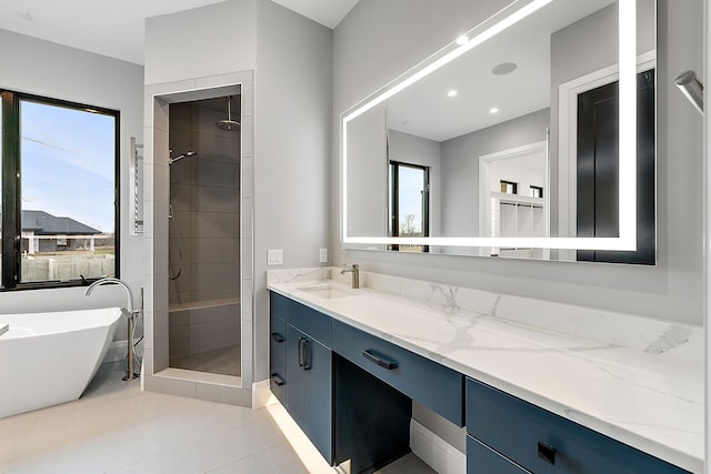 bathroom featuring tile patterned flooring, shower with separate bathtub, and vanity