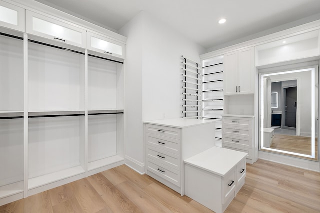 walk in closet with light hardwood / wood-style floors