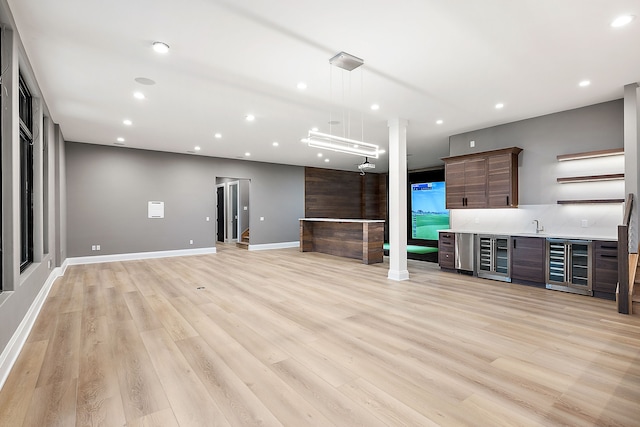 unfurnished living room featuring light hardwood / wood-style floors and sink