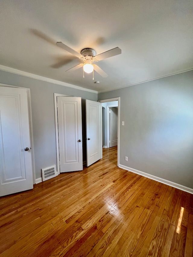 unfurnished bedroom featuring light hardwood / wood-style flooring, ceiling fan, and crown molding