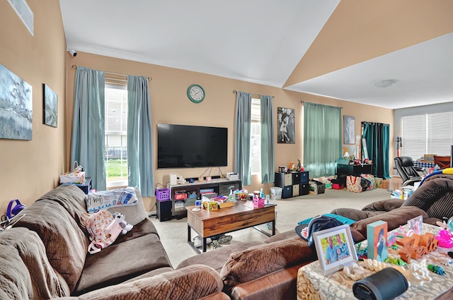 carpeted living area with vaulted ceiling
