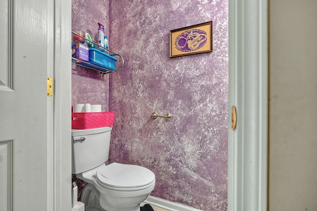 bathroom with baseboards, tile patterned floors, and toilet