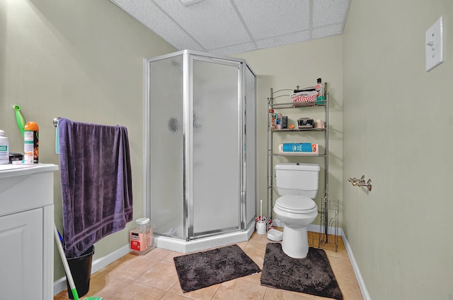 full bath with toilet, tile patterned floors, a paneled ceiling, and a stall shower