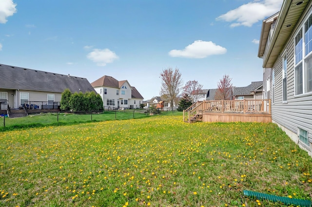 view of yard with a residential view, a wooden deck, and a fenced backyard