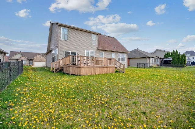 back of property with a yard, a deck, and a fenced backyard