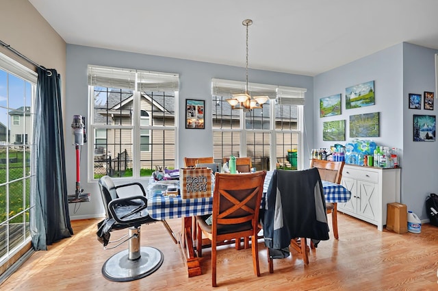 dining space featuring a chandelier, a wealth of natural light, and wood finished floors