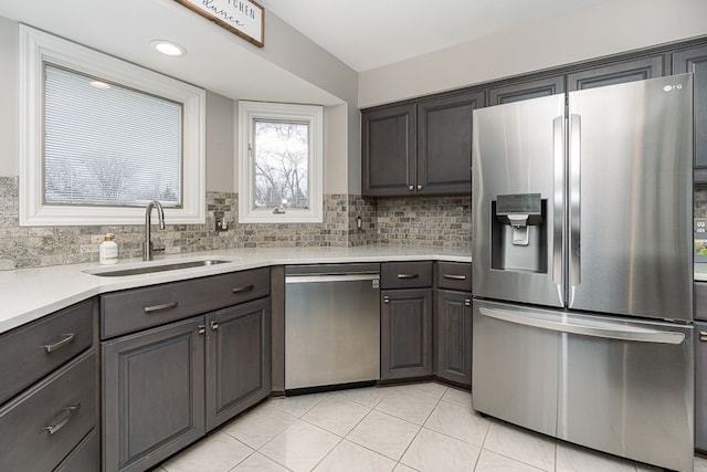 kitchen featuring appliances with stainless steel finishes, sink, dark brown cabinets, and decorative backsplash