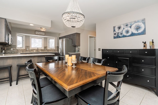 tiled dining room featuring an inviting chandelier