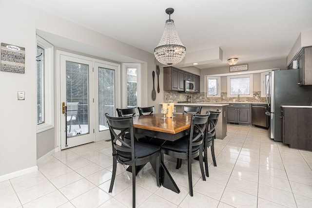 tiled dining room with a notable chandelier