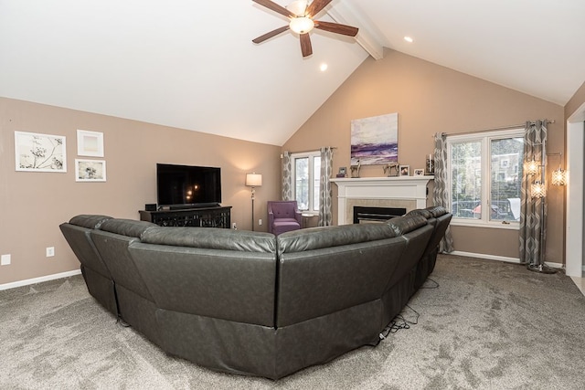 living room featuring high vaulted ceiling, carpet floors, beamed ceiling, ceiling fan, and a tiled fireplace