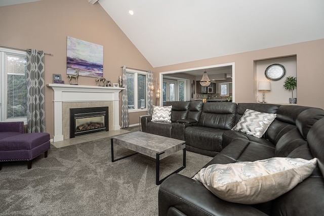 carpeted living room featuring high vaulted ceiling and a tile fireplace