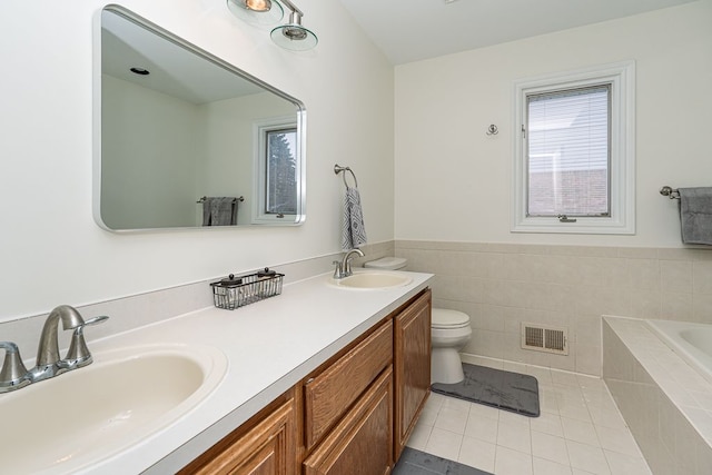 bathroom with vanity, a healthy amount of sunlight, tile patterned floors, and toilet