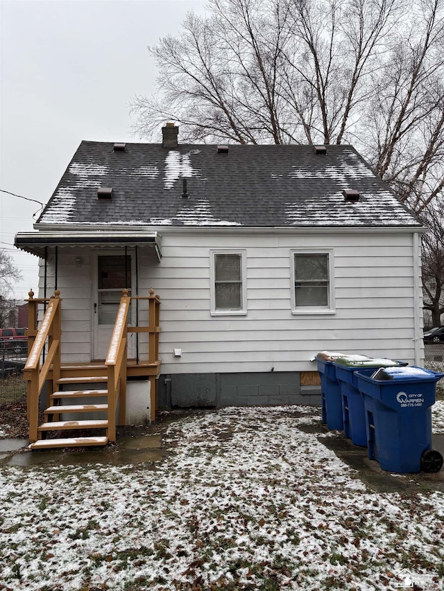 view of snow covered rear of property