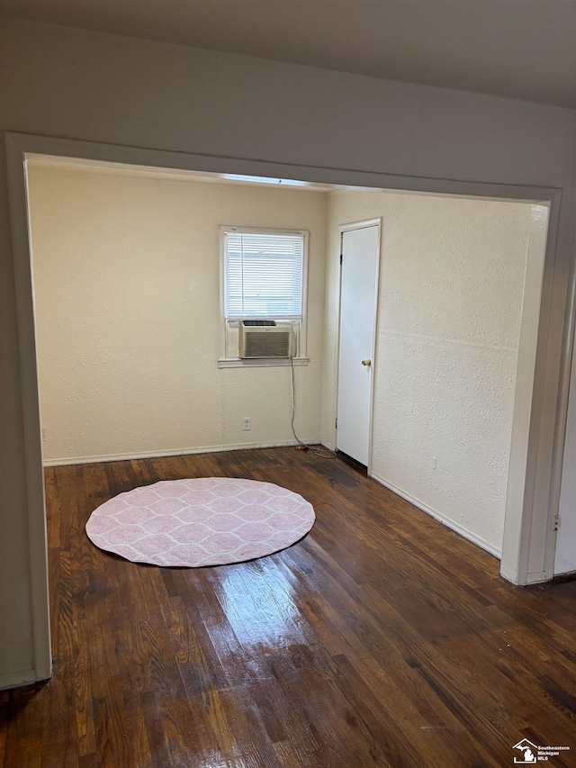 empty room featuring cooling unit and dark hardwood / wood-style floors