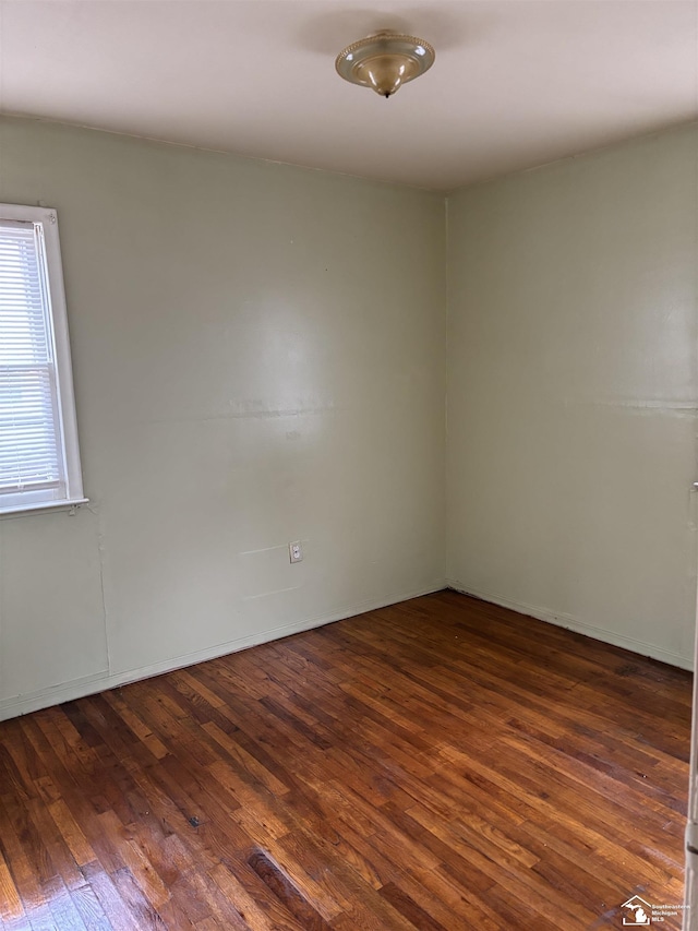 unfurnished room with dark wood-type flooring