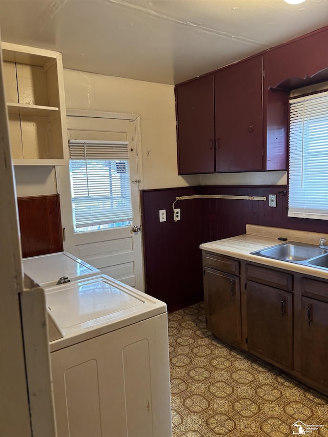 kitchen with dark brown cabinets, washing machine and dryer, and sink