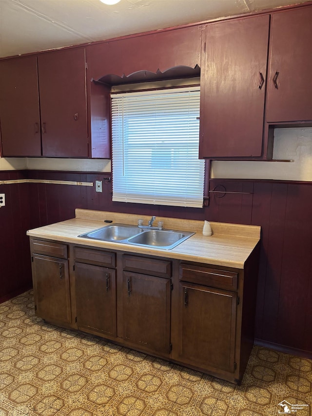 kitchen featuring wood walls and sink