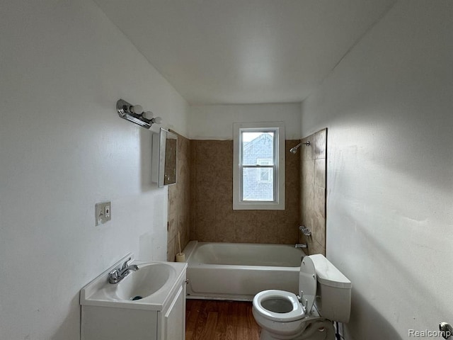 full bathroom with vanity, hardwood / wood-style floors, tiled shower / bath combo, and toilet