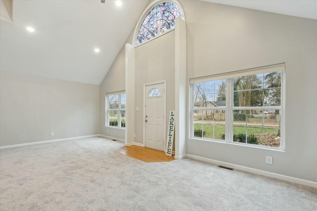 entryway featuring recessed lighting, visible vents, light carpet, high vaulted ceiling, and baseboards