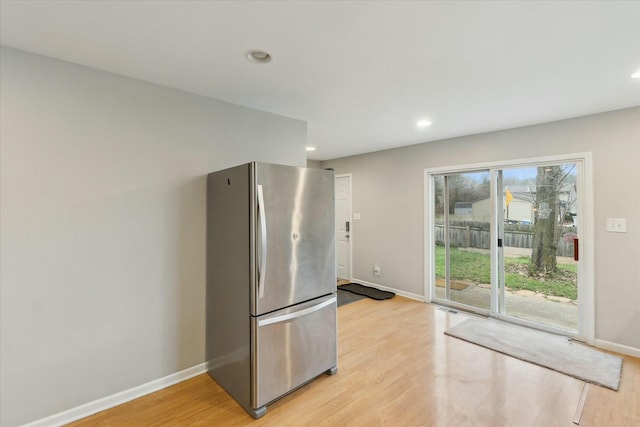 kitchen featuring light wood-type flooring, recessed lighting, baseboards, and freestanding refrigerator