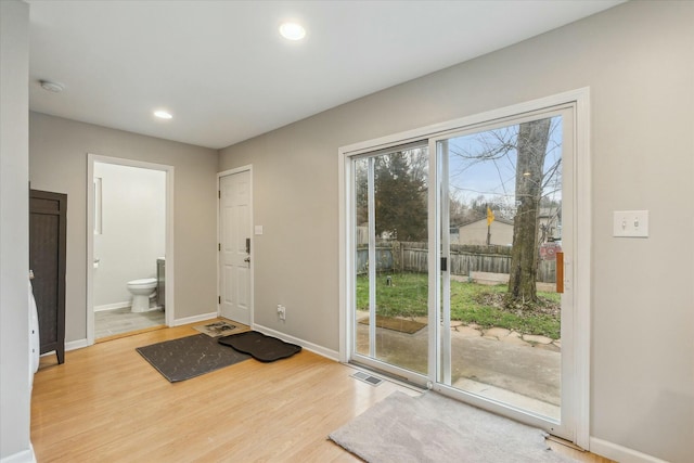 doorway with light wood-style flooring, baseboards, and recessed lighting