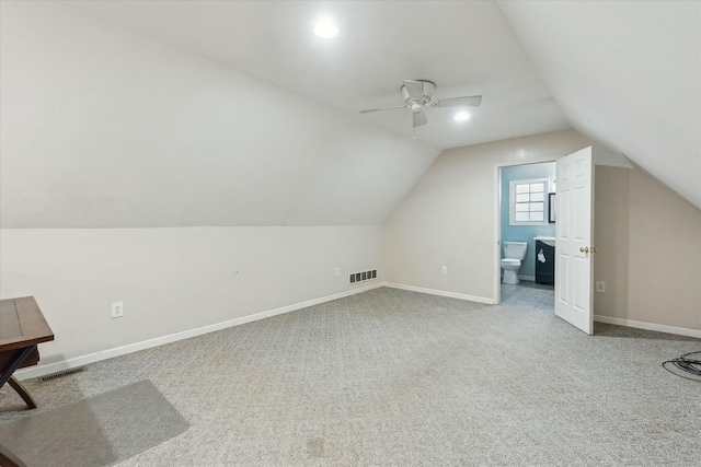 bonus room featuring vaulted ceiling, baseboards, visible vents, and light colored carpet