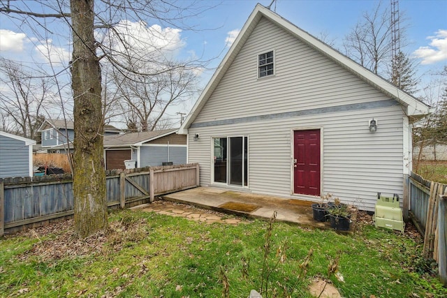 rear view of property featuring a patio, a lawn, and a fenced backyard