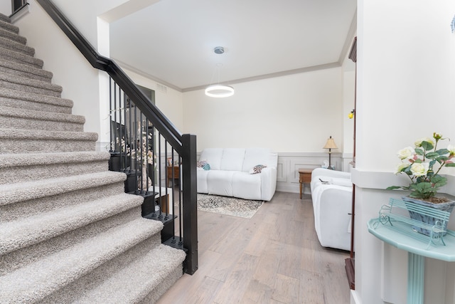 stairs with crown molding and hardwood / wood-style flooring