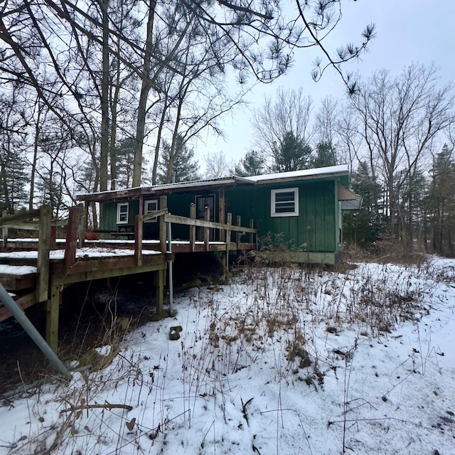 snow covered house with a wooden deck