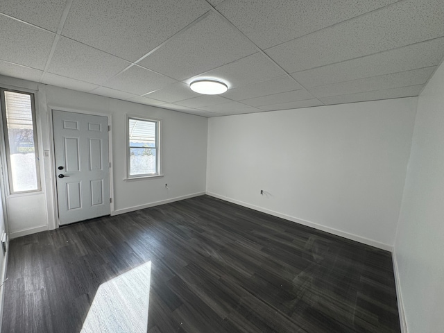 interior space with a paneled ceiling and dark hardwood / wood-style flooring