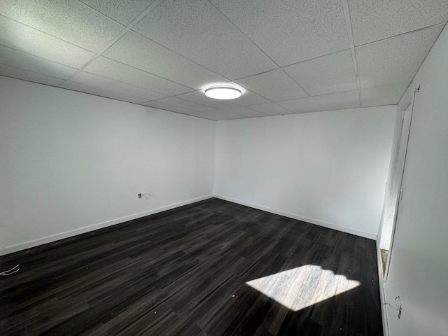 unfurnished room featuring a drop ceiling and dark wood-type flooring