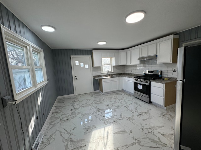 kitchen with decorative backsplash, sink, white cabinetry, and stainless steel appliances