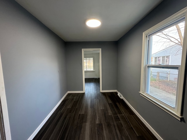 corridor with dark hardwood / wood-style flooring