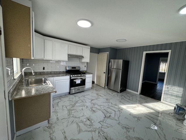 kitchen featuring decorative backsplash, white cabinetry, sink, and appliances with stainless steel finishes