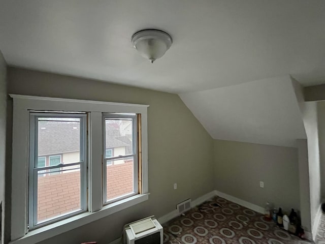 bonus room with heating unit and vaulted ceiling