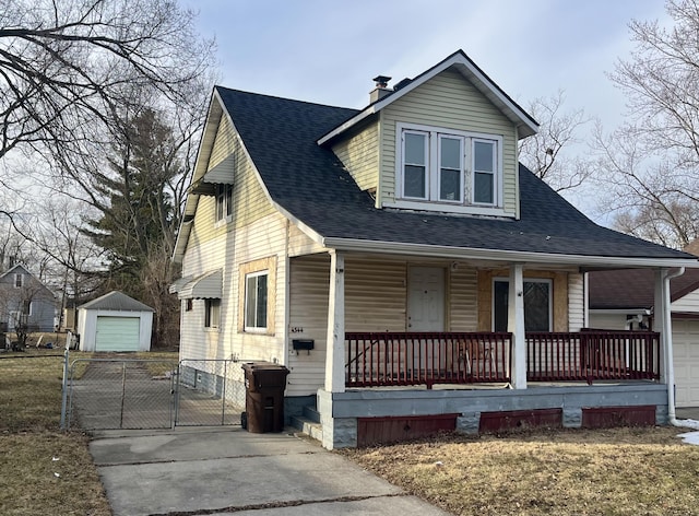 view of front of house featuring a porch, a garage, and an outdoor structure