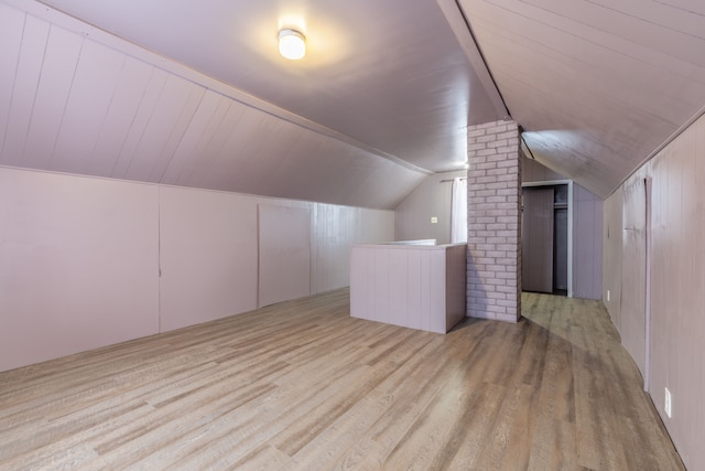 additional living space with lofted ceiling and light hardwood / wood-style flooring