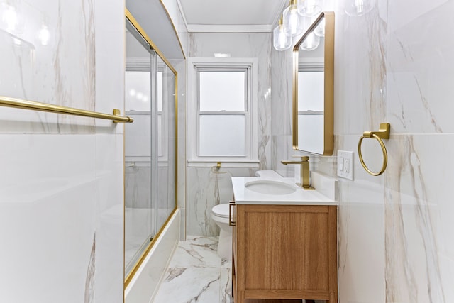 full bathroom with combined bath / shower with glass door, vanity, toilet, and tile walls