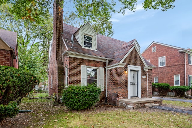 cape cod house with a front lawn