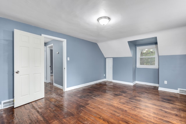 bonus room with dark hardwood / wood-style flooring and lofted ceiling