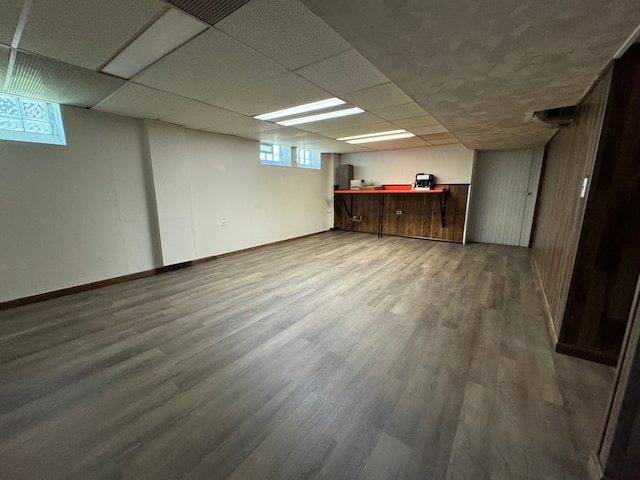 basement with a drop ceiling and hardwood / wood-style floors