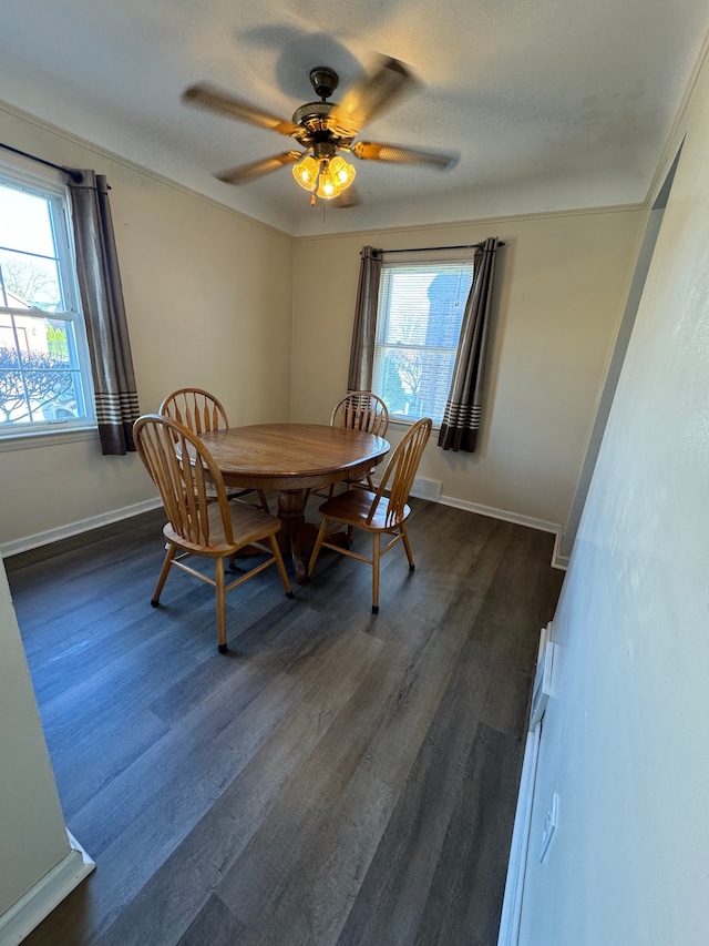 dining room with ceiling fan, dark hardwood / wood-style flooring, and a textured ceiling